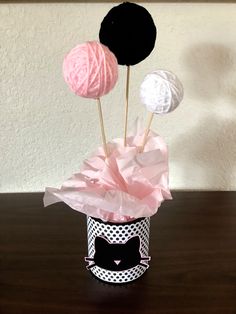 three balls of yarn in a cup with tissue paper on the top and one ball of yarn on the bottom