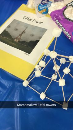 marshmallow eiffel tower towers are displayed on a blue table with candy