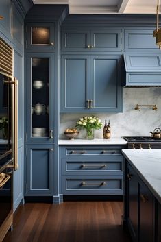 a kitchen with blue cabinets and wood floors