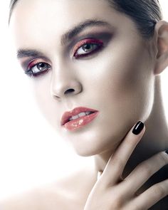 a woman with red and black makeup is posing for the camera