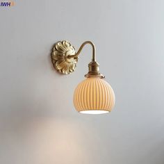 a wall light that is on the side of a wall next to a lamp shade