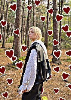 a woman standing in the woods surrounded by hearts