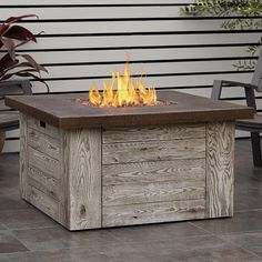 an outdoor fire pit sitting on top of a tile floor next to a wooden bench