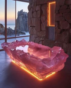 a large pink stone bowl sitting on top of a table in front of a window