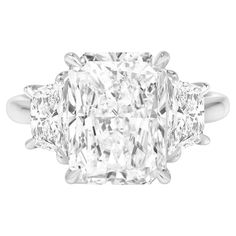 an oval cut diamond ring with three princess cut diamonds on the shoulders and side stones