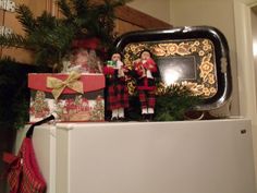 christmas decorations on top of a refrigerator in a kitchen