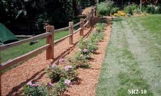 a fenced in garden with flowers and grass