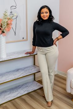 a woman standing in front of a table with flowers on it and her hands on her hips