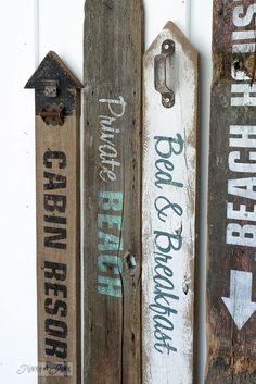 three wooden signs hanging on the wall with arrows pointing in different directions and words painted on them