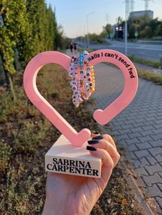 Hey fans! Are you as excited as we are for the upcoming tour? While waiting, we're making friendship bracelets, and we know many of you are too! So we created a unique way to display them so you can enjoy them every day. Introducing a fully customizable bracelet stand - choose your color and personalize the text on the heart. Pick a favorite quote or a special message for a gift. Both options are perfect, and we can't wait to create something special for you! Novelty Pink Friendship Bracelets As Gift, Pink Heart Friendship Bracelets For Best Friend Gift, Pink Heart-shaped Friendship Bracelets, Bracelet Stand, Bracelet Holders, Making Friendship Bracelets, Sabrina Carpenter, Gift Registry, Friendship Bracelets