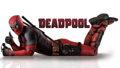 deadpool is laying on the ground with his thumbs up