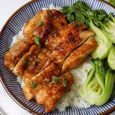 a blue and white plate topped with chicken, broccoli and rice