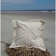 a starfish pillow on the beach with sea oats in it's foreground