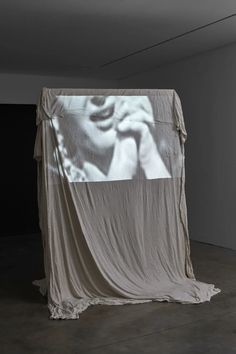 an image is projected on the wall behind a draped cloth