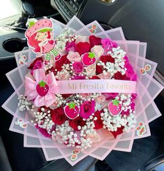 a bouquet of flowers sitting on top of a car seat in front of a steering wheel