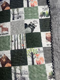 a baby quilt with animals and trees on the front, along with words that read be strong