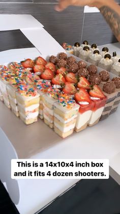 a table topped with lots of desserts and strawberries on top of cake boxes