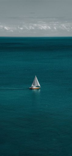 a small sailboat floating on top of a large body of water