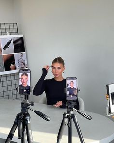 a woman taking a selfie with her cell phone in front of a tripod