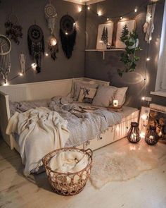 a bedroom with lights strung from the ceiling and blankets on the bed, along with other decorations