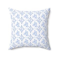 a blue and white pillow with an intricate design on the front, sitting against a white background