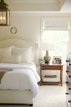 a bedroom with white linens and pillows on the bedspread next to a night stand