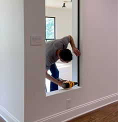 a man is looking through a window in a house