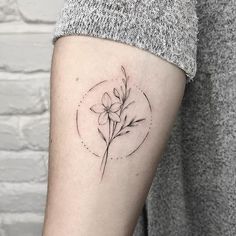 a small flower tattoo on the arm