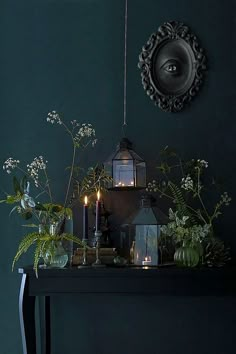 a table topped with plants and candles next to a mirror