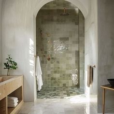 an arched doorway leads to a tiled bathroom