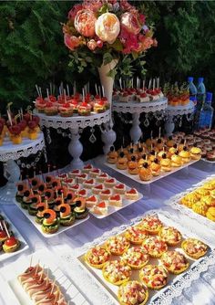 a table topped with lots of trays filled with cakes and cupcakes on top of plates