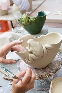 someone is working on a vase with two hands