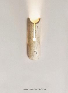 a light that is on the side of a white wall next to a wooden pole