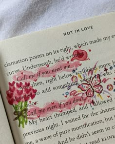 an open book with watercolors and writing on the pages in pink, red and green