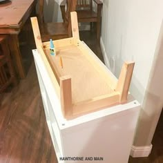 an unfinished kitchen sink in the middle of a room with chairs and a table behind it