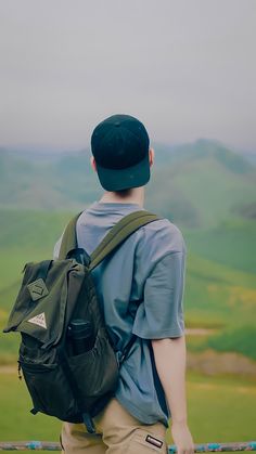 a man with a backpack looking over a fence