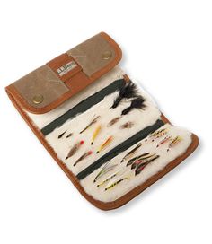 the case is made out of leather and has different types of fishing flies on it