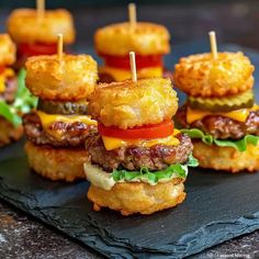 mini burgers with cheese, tomato and onion on a slate platter for appetizers