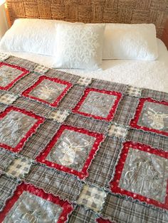 the bed is made up with red and gray quilts