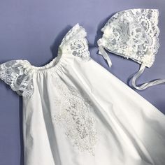 a white dress and bonnet on a purple background