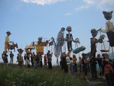 a group of people standing on top of a grass covered field next to each other