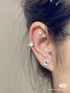 a woman with three stars on her ear and one behind the ear is wearing an ear cuff