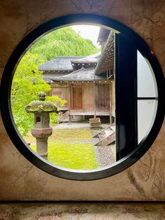 a round window view of a house in the woods