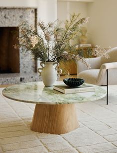 a vase with flowers sitting on top of a table in front of a fire place