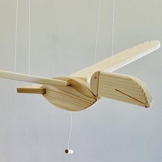 a wooden toy airplane hanging from strings