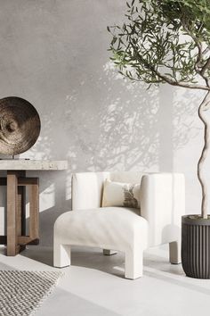 a white chair sitting next to a table with a potted plant