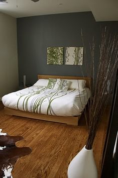 a bedroom with wood floors and green walls