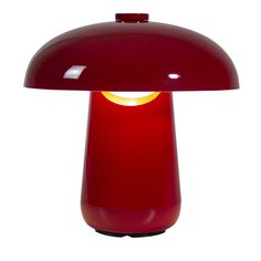 a red table lamp with a yellow light on it's side and a white background