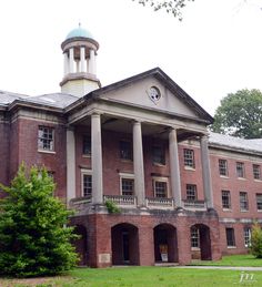 an old brick building with columns and a clock tower