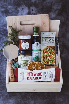 a wooden box filled with food and condiments on top of a gray surface